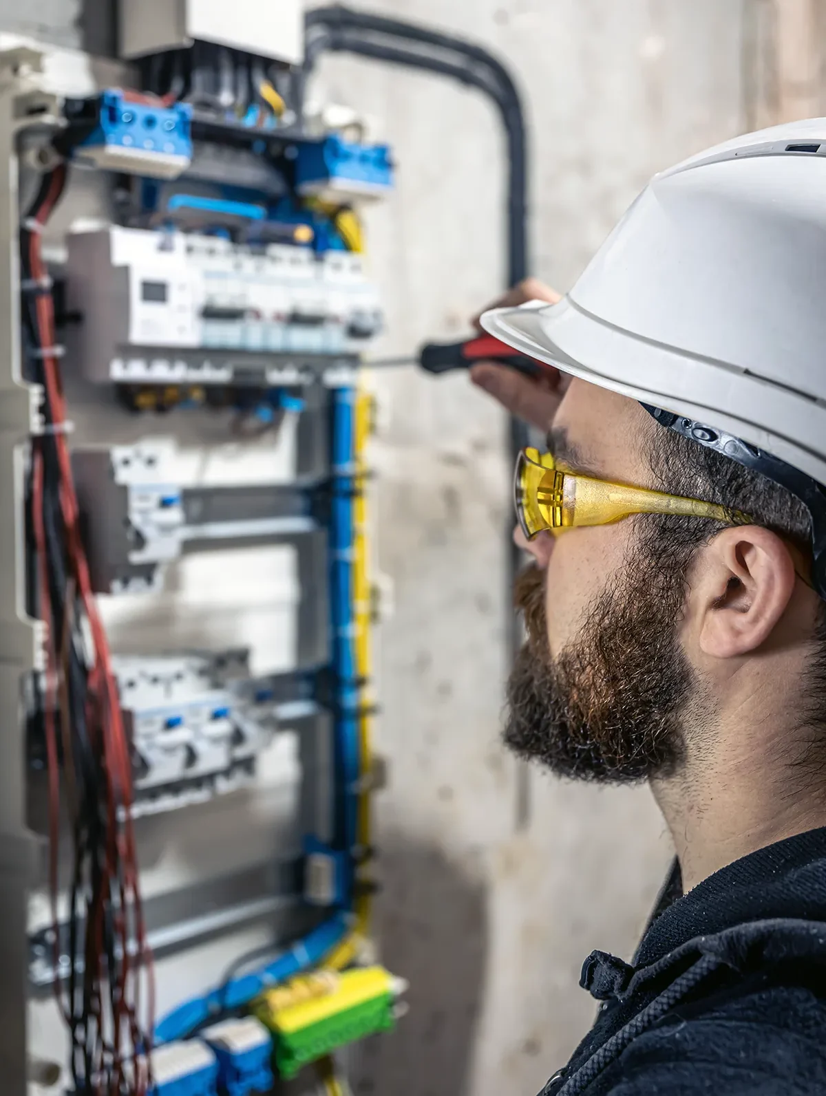 male electrician works switchboard with electrical connecting cable e1781551913780